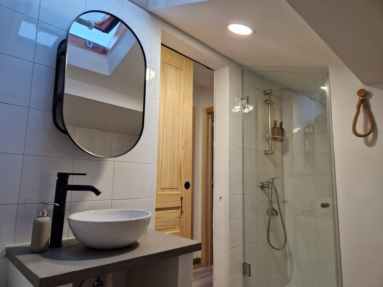 Baño con ducha y lavabo sobre encimera