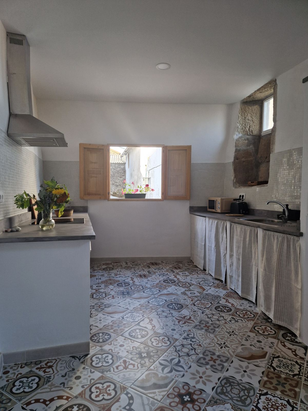 Cocina con suelo hidráulico y contraventanas de madera
